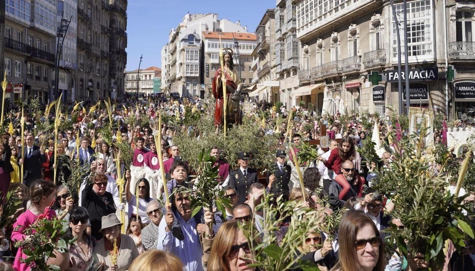 Centenares de fieles aclamaron con sus ramos y palmas  durante la bendición en Porta do Sol con el paso de La Borriquita.