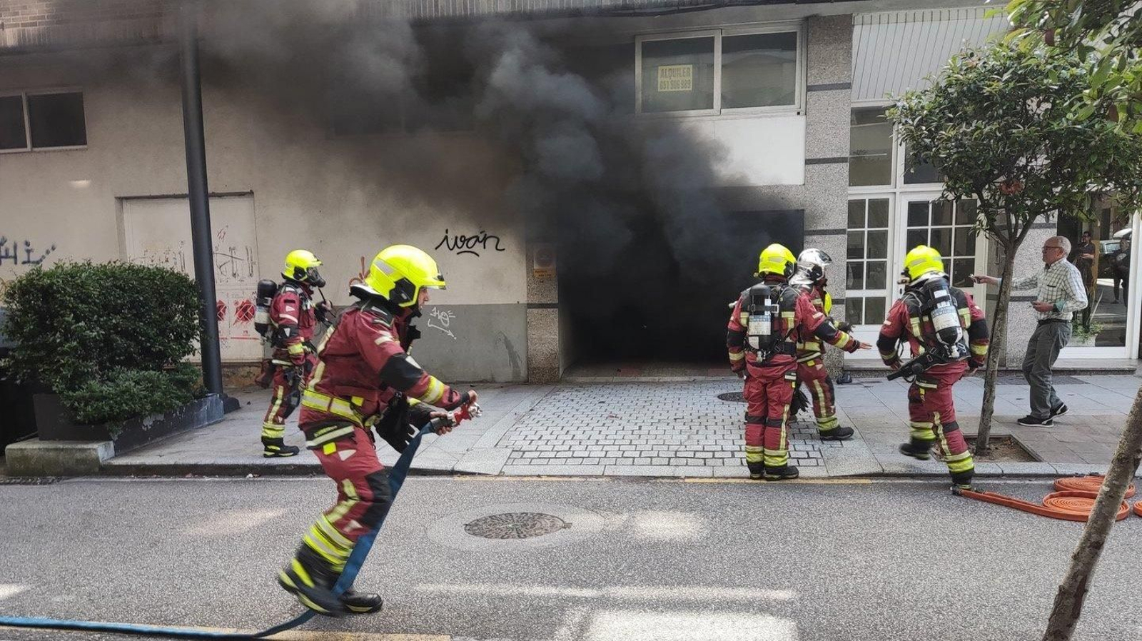 Los bomberos, en el garaje en el que se produjo el incendio. // Vicente Alonso