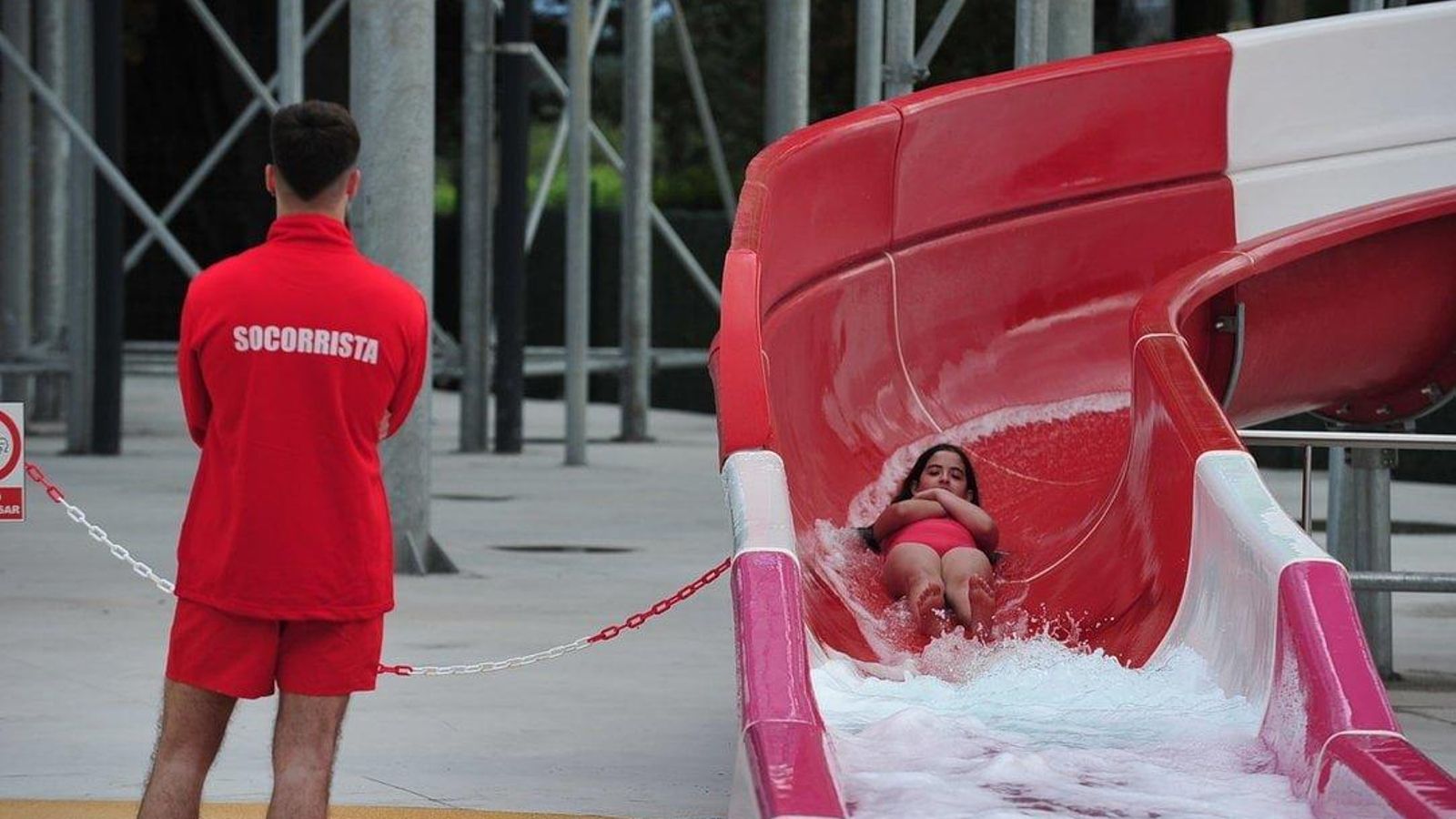 Una niña baja por uno de los toboganes con la supervisión de un socorrista. // José Paz