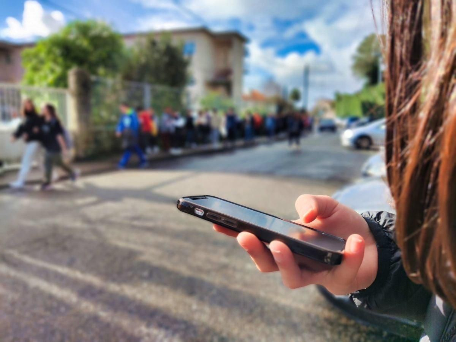 Una adolescente utiliza el móvil a la salida de uno de los institutos de Vigo.