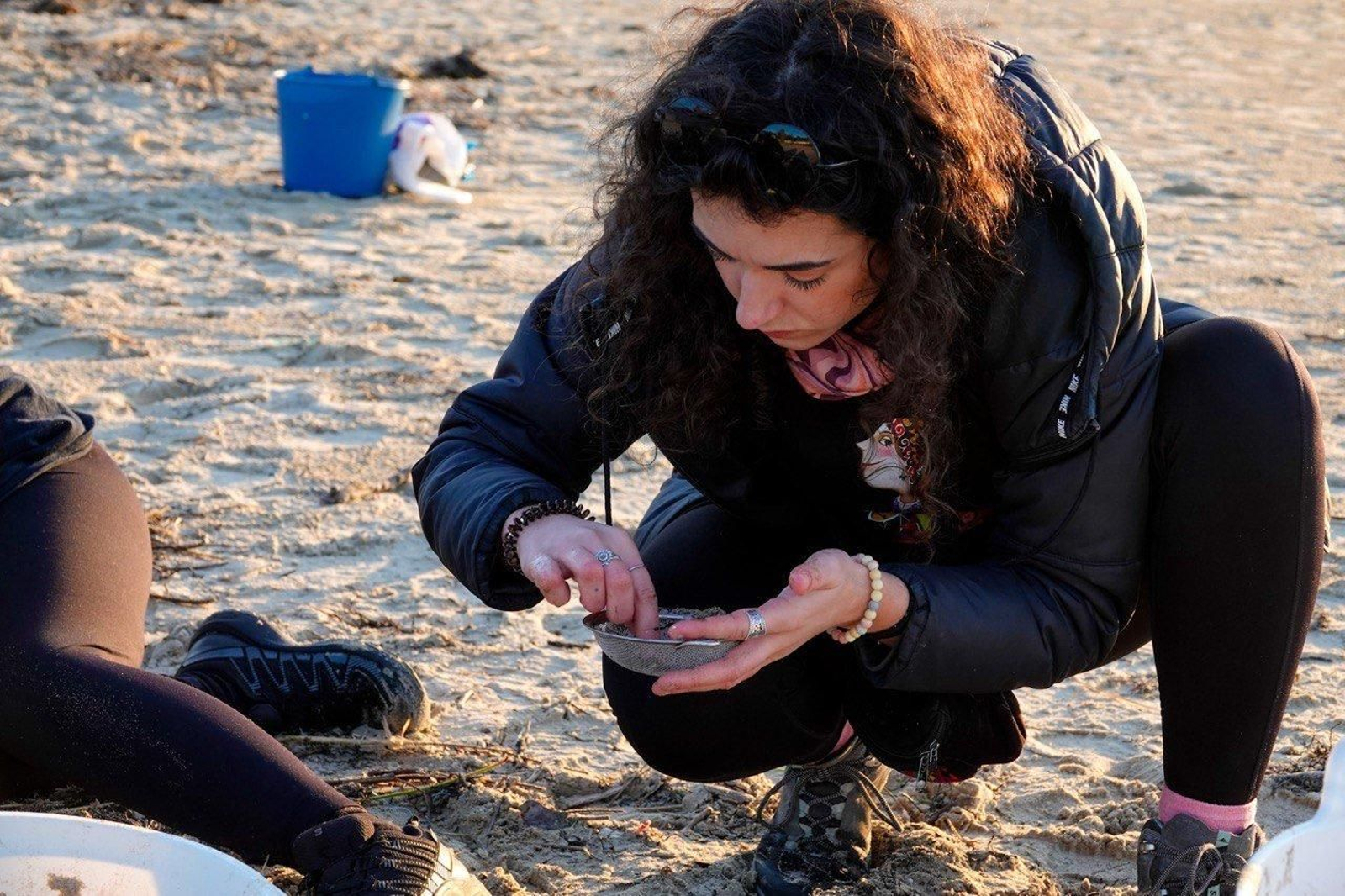 Voluntarios recogen pellets de plástico.
