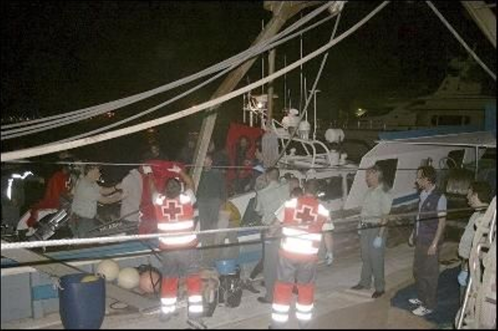 Personal de Cruz Roja y agentes de la Guardia Civil atienden los inmigrantes (Foto: EFE)