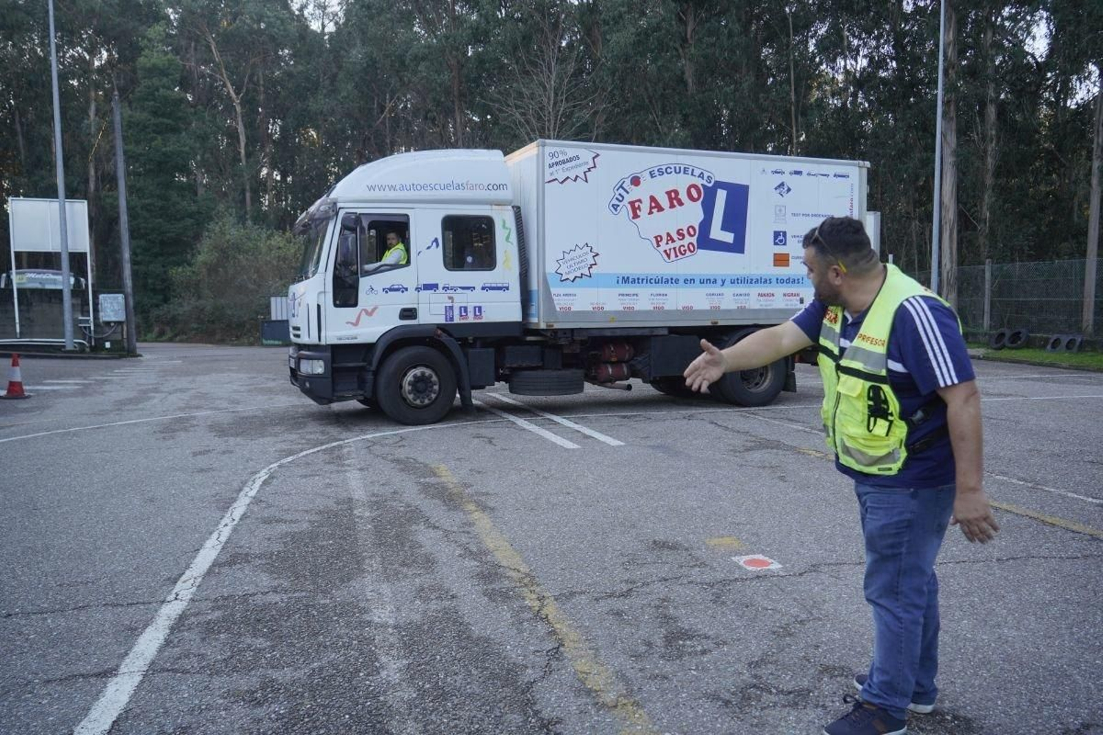 Un profesor hace indicaciones a un conductor de camión durante unas prácticas.