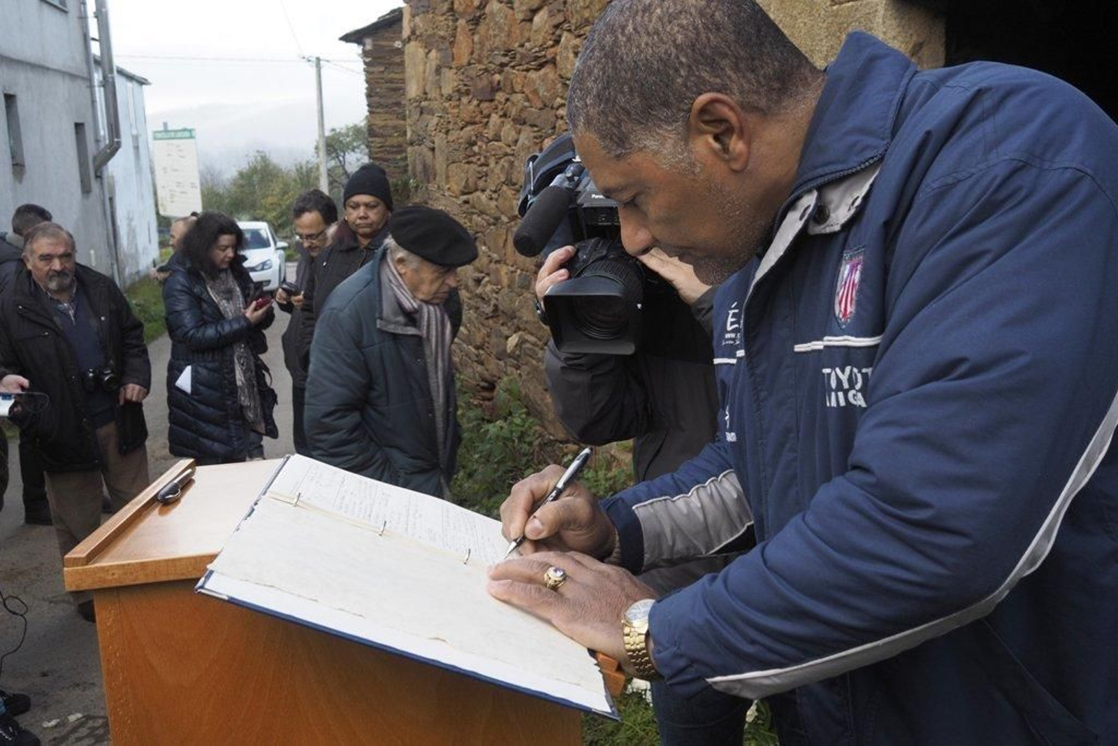 Un cubano firma en el libro de condolencias dispuesto ante la casa de los Castro en Láncara.