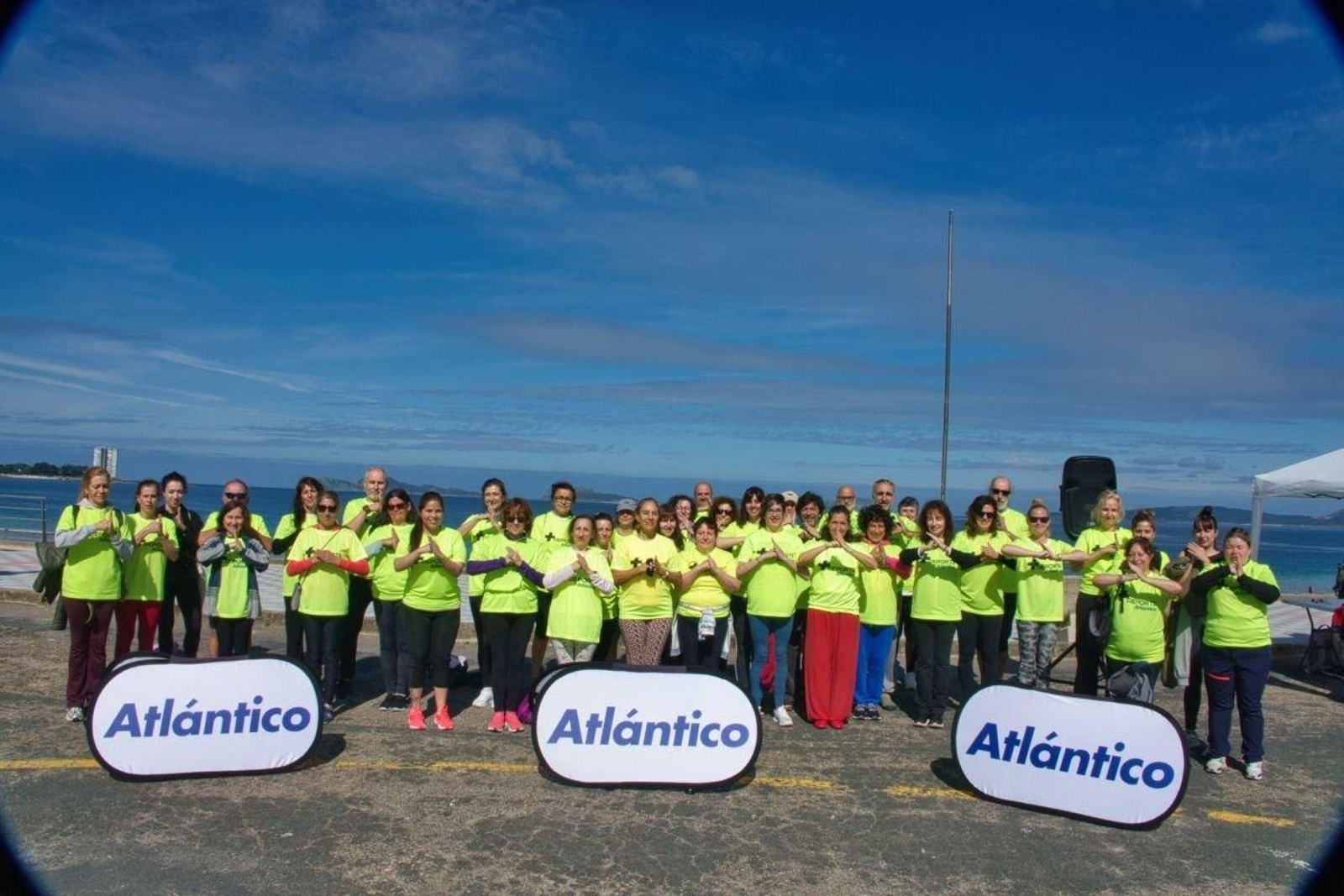 Los participantes en la sesión de taichí de +Deporte Atlántico y el centro Shalom saludan al final de la actividad en la playa de Samil.