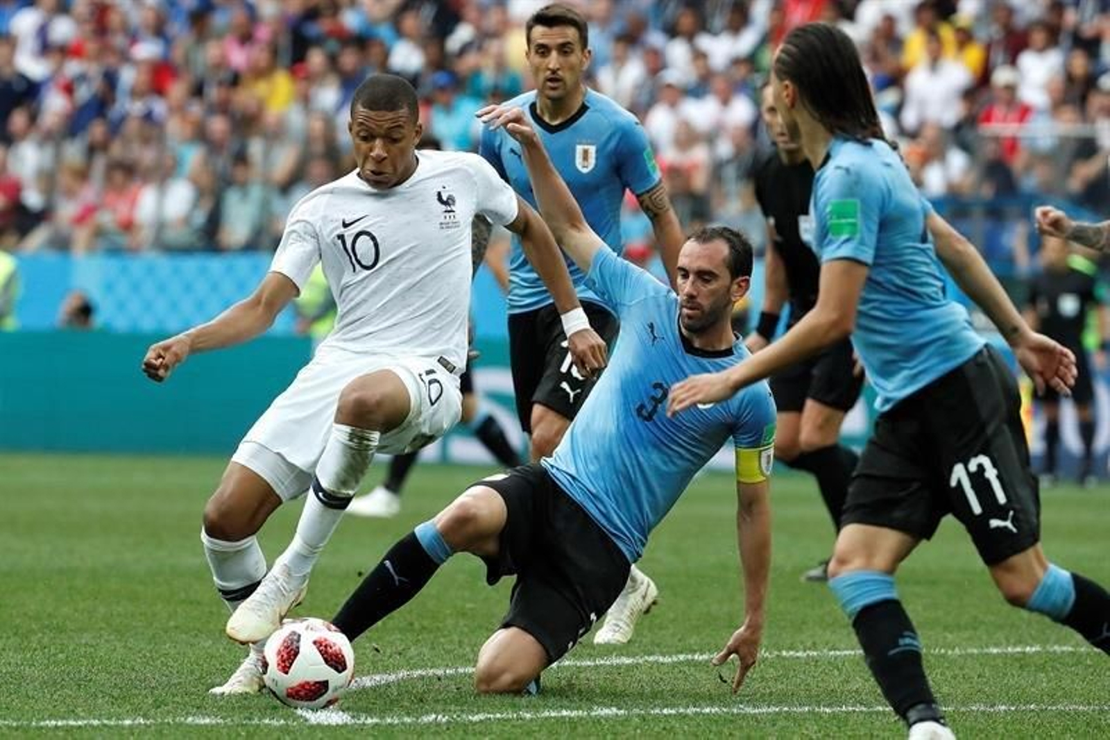 El delantero francés Kylian Mbappé y el defensa uruguayo Diego Godín durante el partido Uruguay-Francia