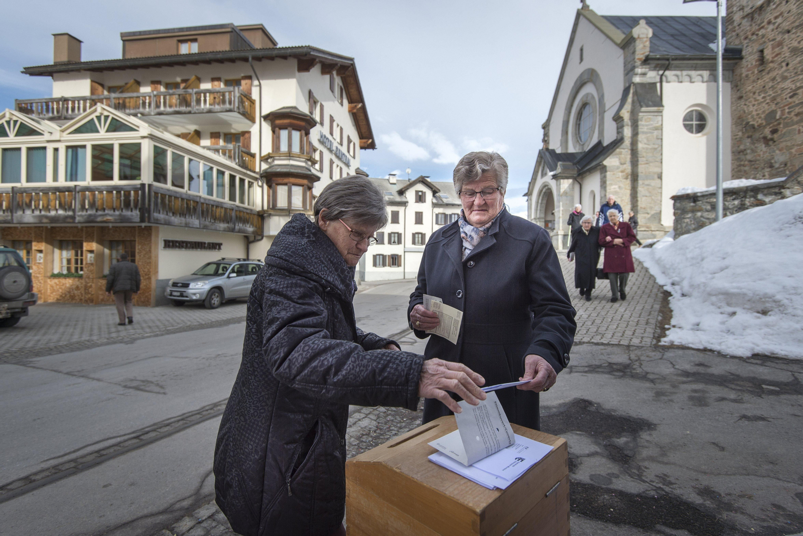 Dos mujeres ejercen su derecho a voto en el referéndum, a la salida de la iglesia en Obersaxen.