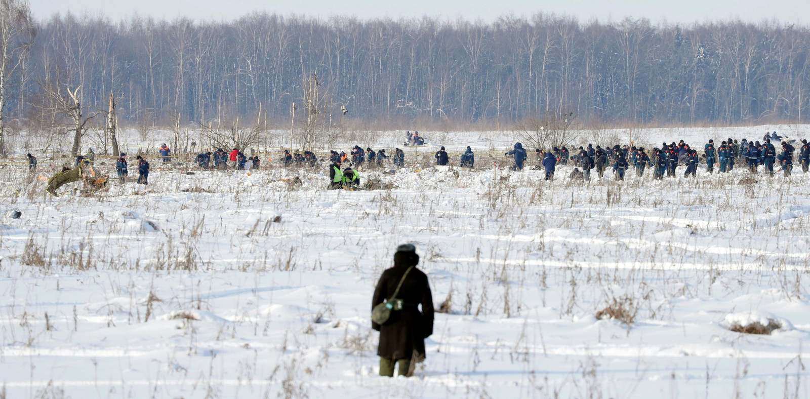 Un soldado observa la labor de los equipos de rescate mientras asegura la zona en el lugar del accidente.
