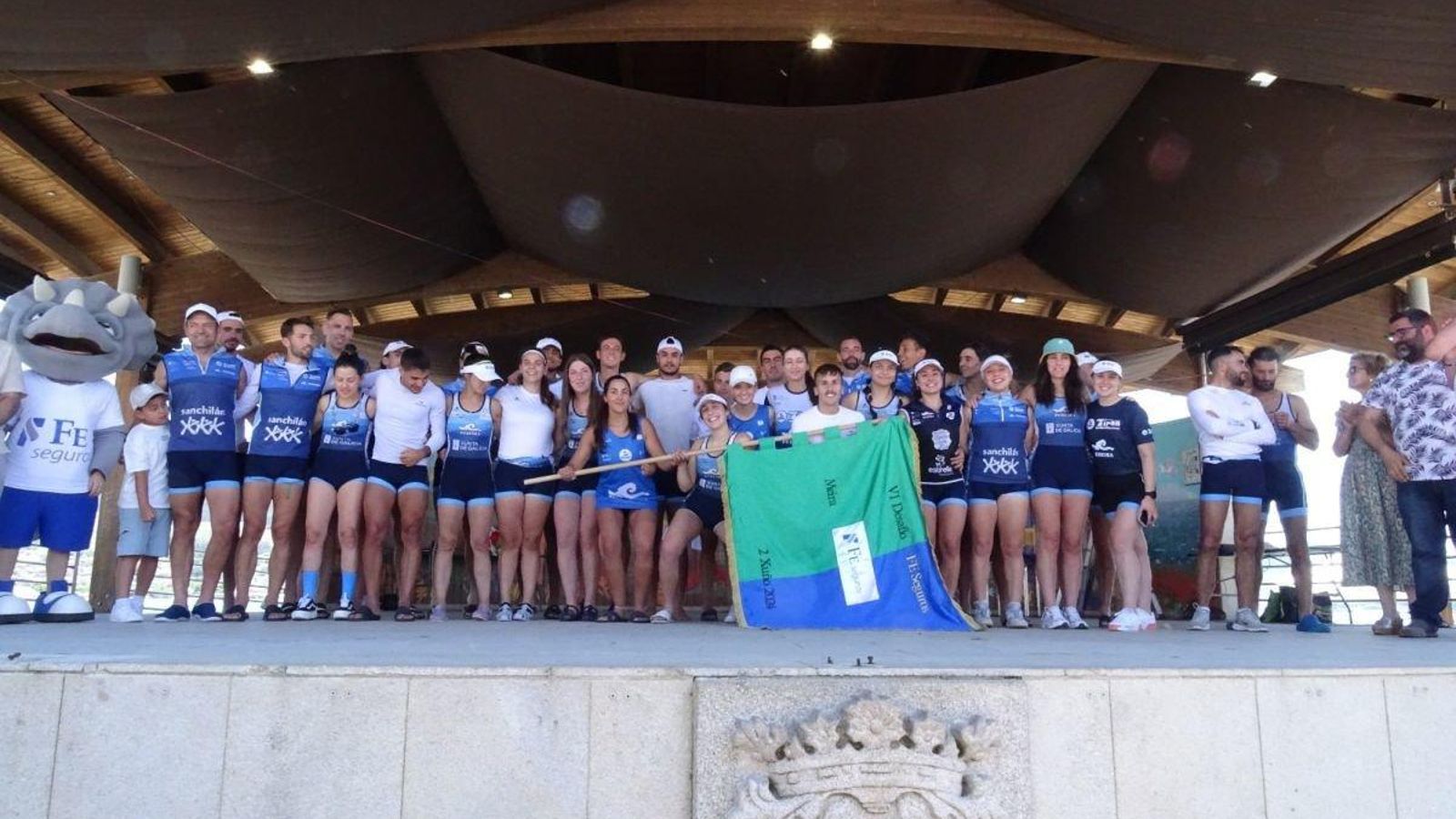 Todos los deportistas de Tirán celebran la victoria con la bandera en el moañés paseo do Fisgón.