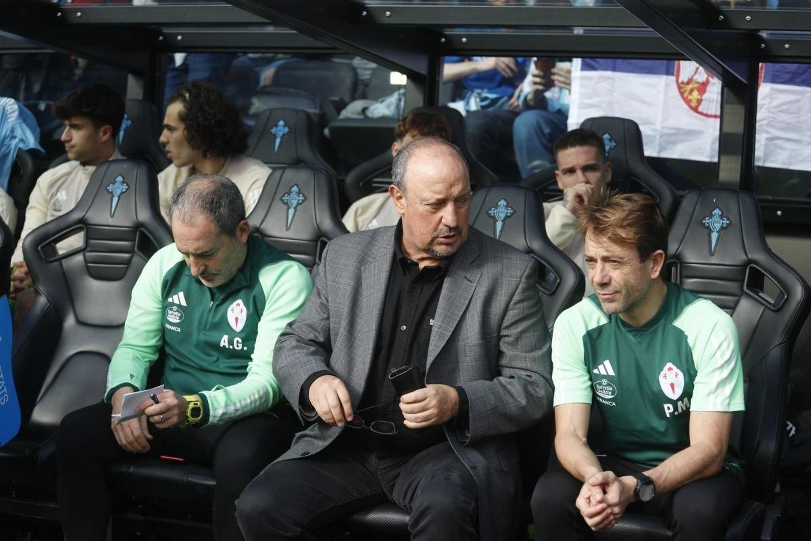 Rafa Benítez charla con sus ayudantes en el banquillo de Balaídos.