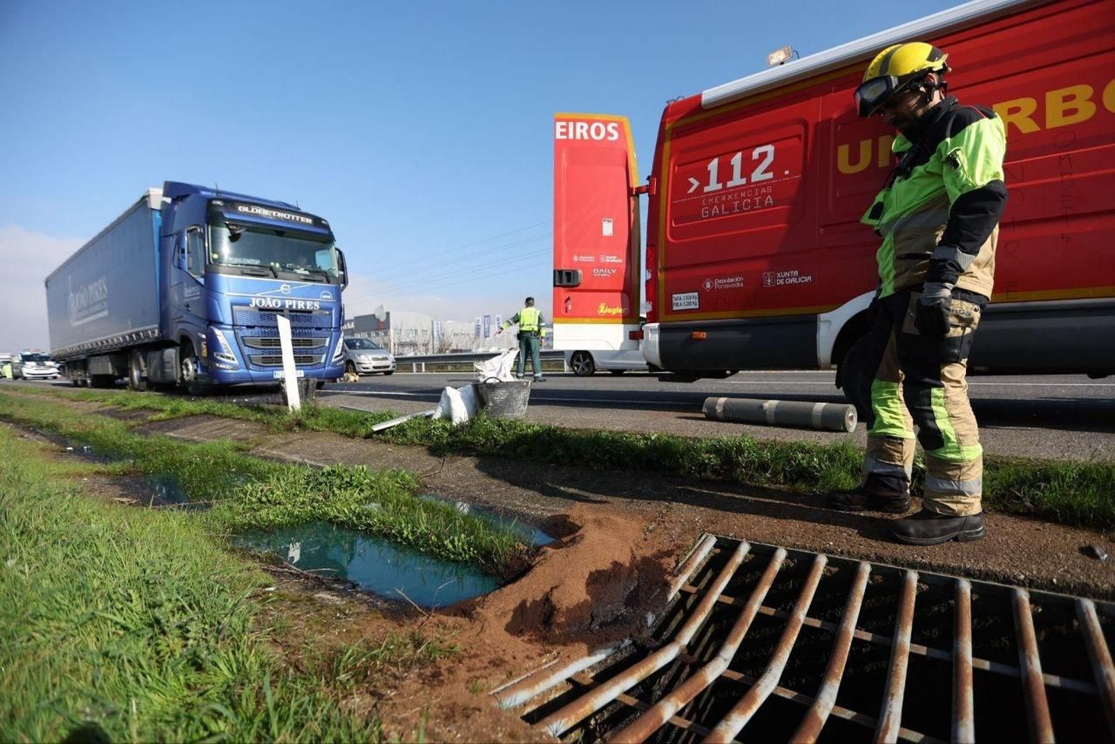 Un bombero controla el vertido de combustible de un camión en la A-55. // Alberte