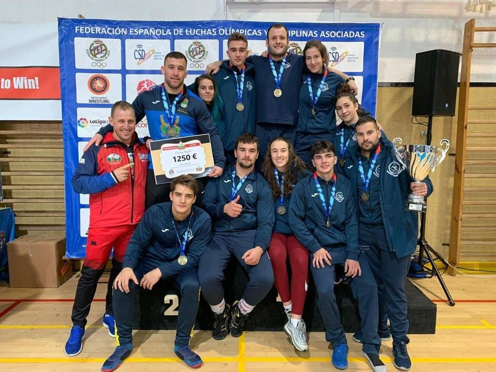 Los luchadores gallegos posan con el trofeo de vencedores.
