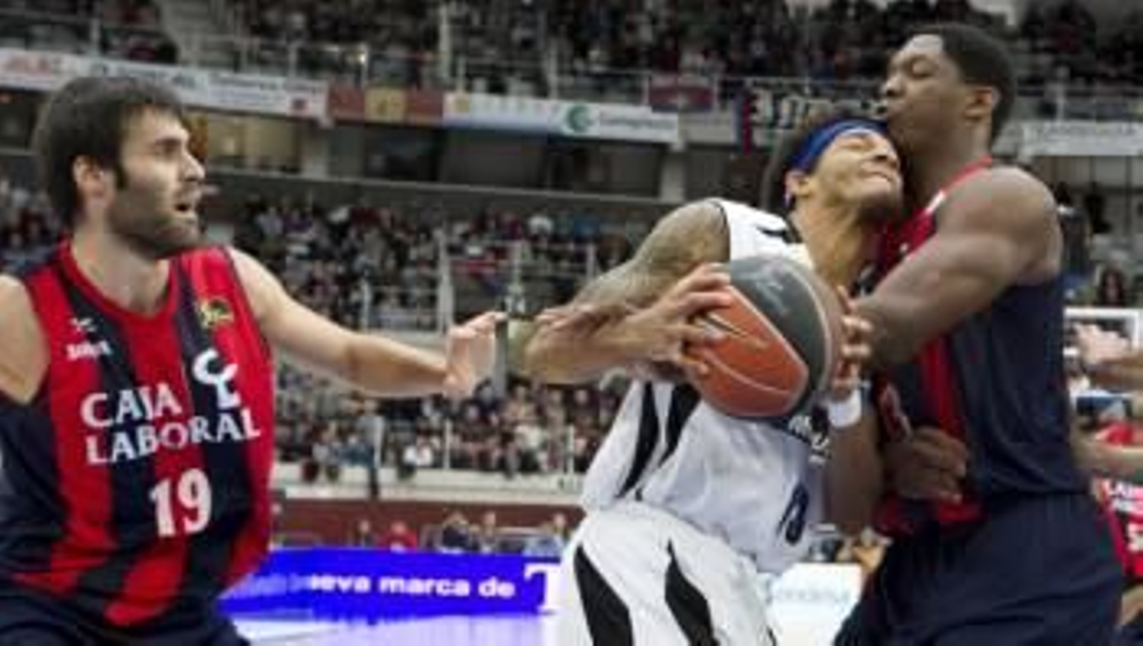 El alero estadounidense del Blusens Monbus Obradoiro, Devon Washington (c) choca con el pívot francés del Caja Laboral Baskonia de Vitoria Kevin Seraphin (Foto: EFE)