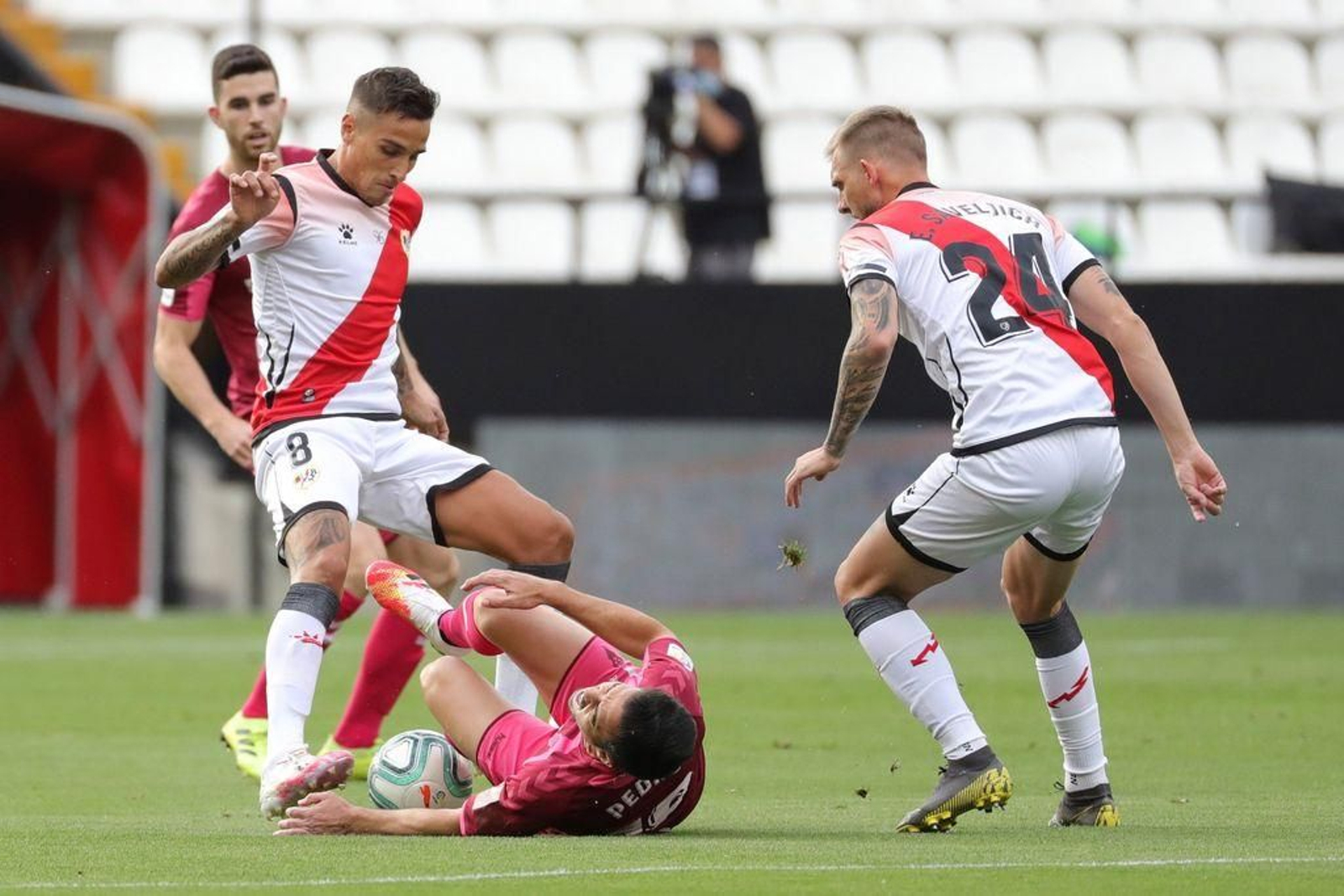 Óscar Trejo disputa un balón con Pedro Sánchez, del Albacete, ante la mirada de Esteban Saveljic.