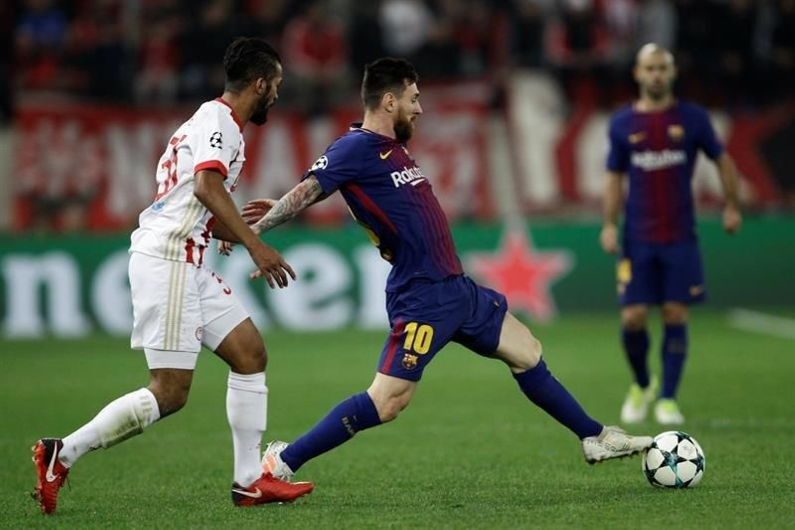 Mehdi Carcela-Gonzalez (i) de Olympiacos disputa un balón con Lionel Messi (c)