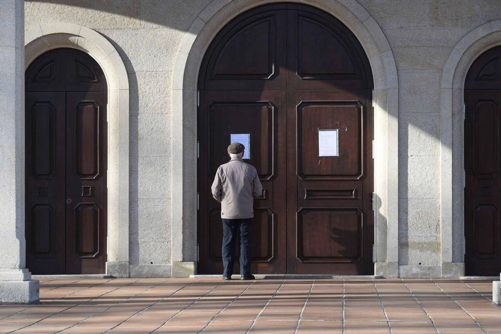 Un feligrés se informa a la puerta del tempo.