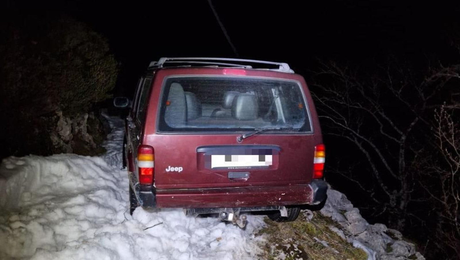 Coche atrapado en una pista forestal por la nieve. // EP