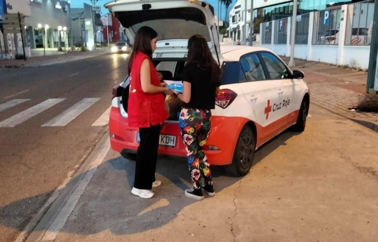 En la imagen una voluntaria de Cruz Roja presta ayuda a una mujer.
