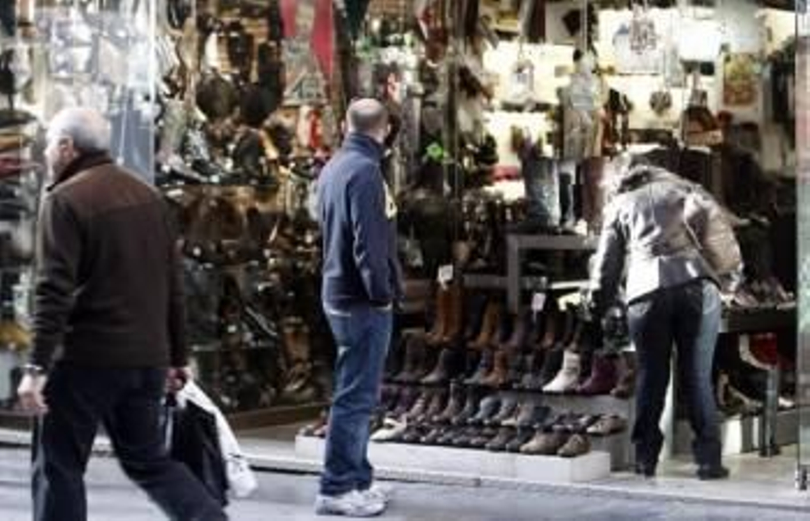 Una mujer elige zapatos en una tienda.