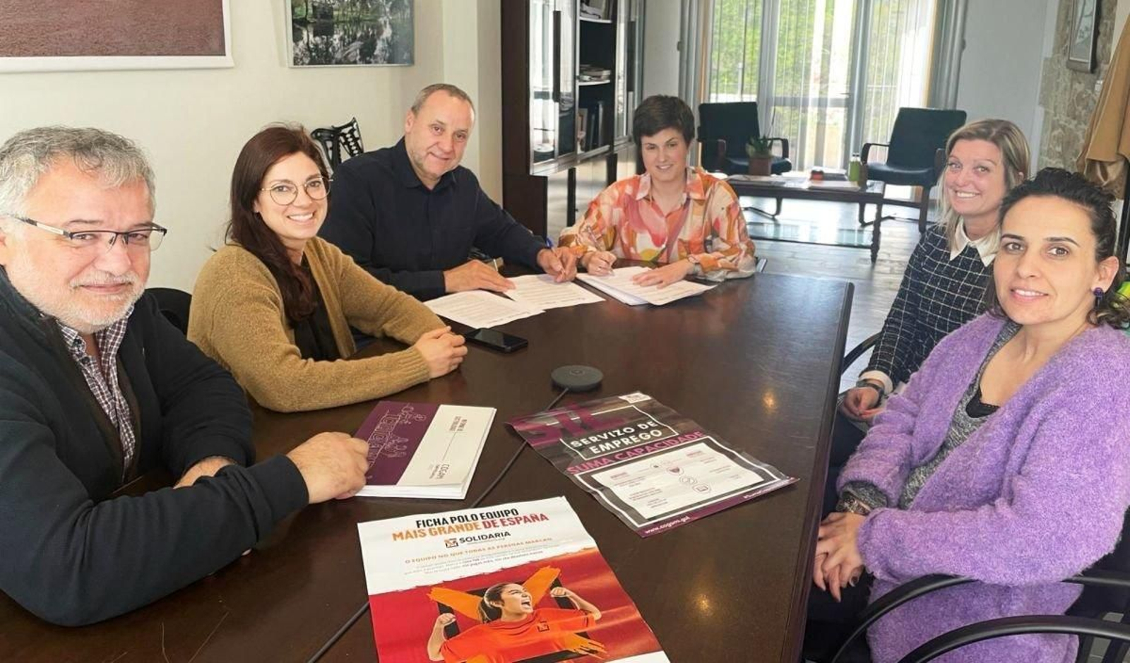 Ánxela Fernández y Beatriz Rodríguez con miembros de Cogami durante la firma del convenio.