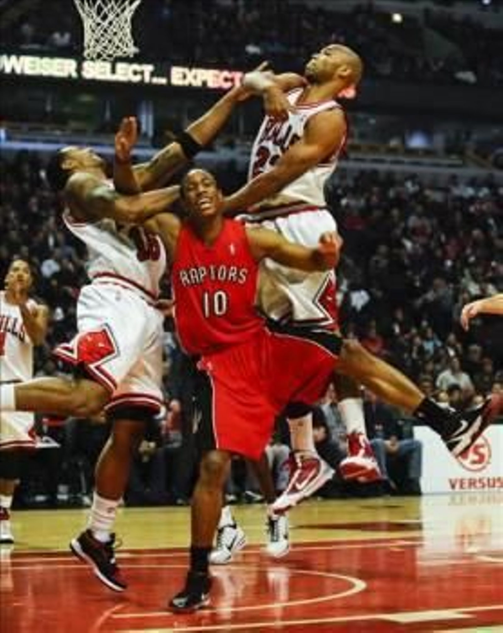 El jugador de los Raptors de Toronto DeMar DeRozan (c) disputa el balón con James Johnson (i) y Taj Gibson (d) de los Bulls de Chicago hoy, sábado 5 de diciembre de 2009, durante el primer periodo del partido de baloncesto de la NBA en el United Center en
