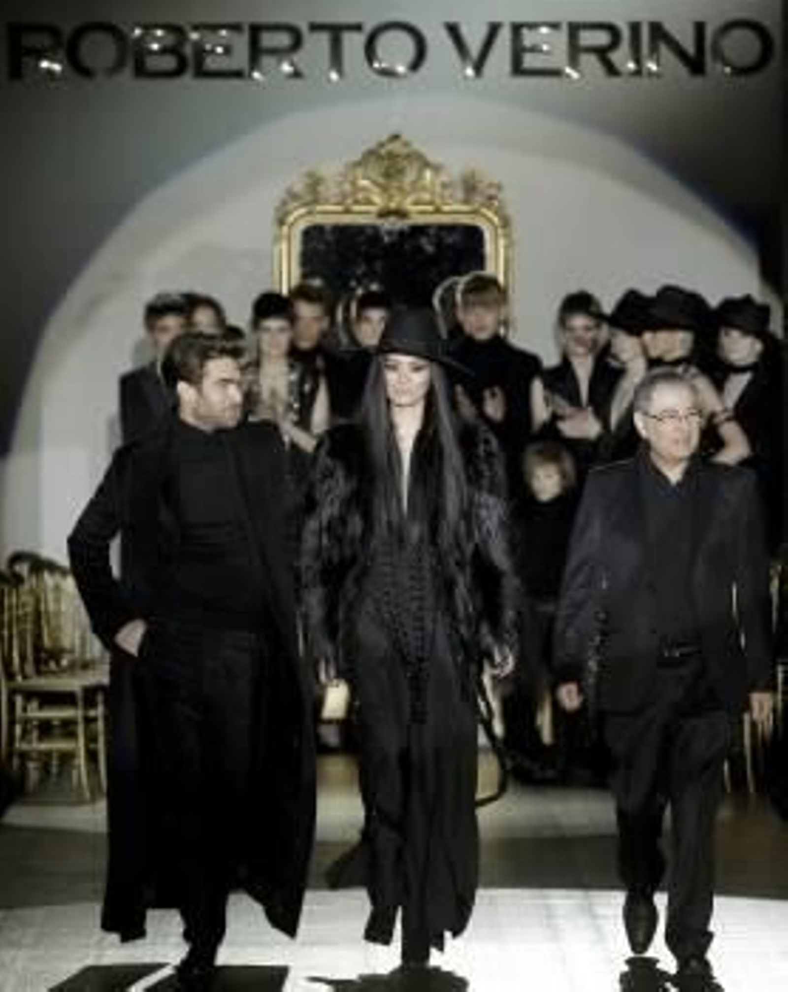 El diseñador gallego Roberto Verino (d) sobre la pasarela, al finalizar el desfile, junto al modelo vasco Jon Kortajarena (i), la top china Ming Xi (c). EFE