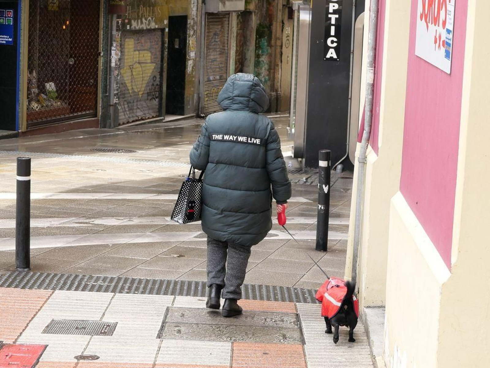 Una mujer con el lema "The way we live" en la espalda del plumífero.