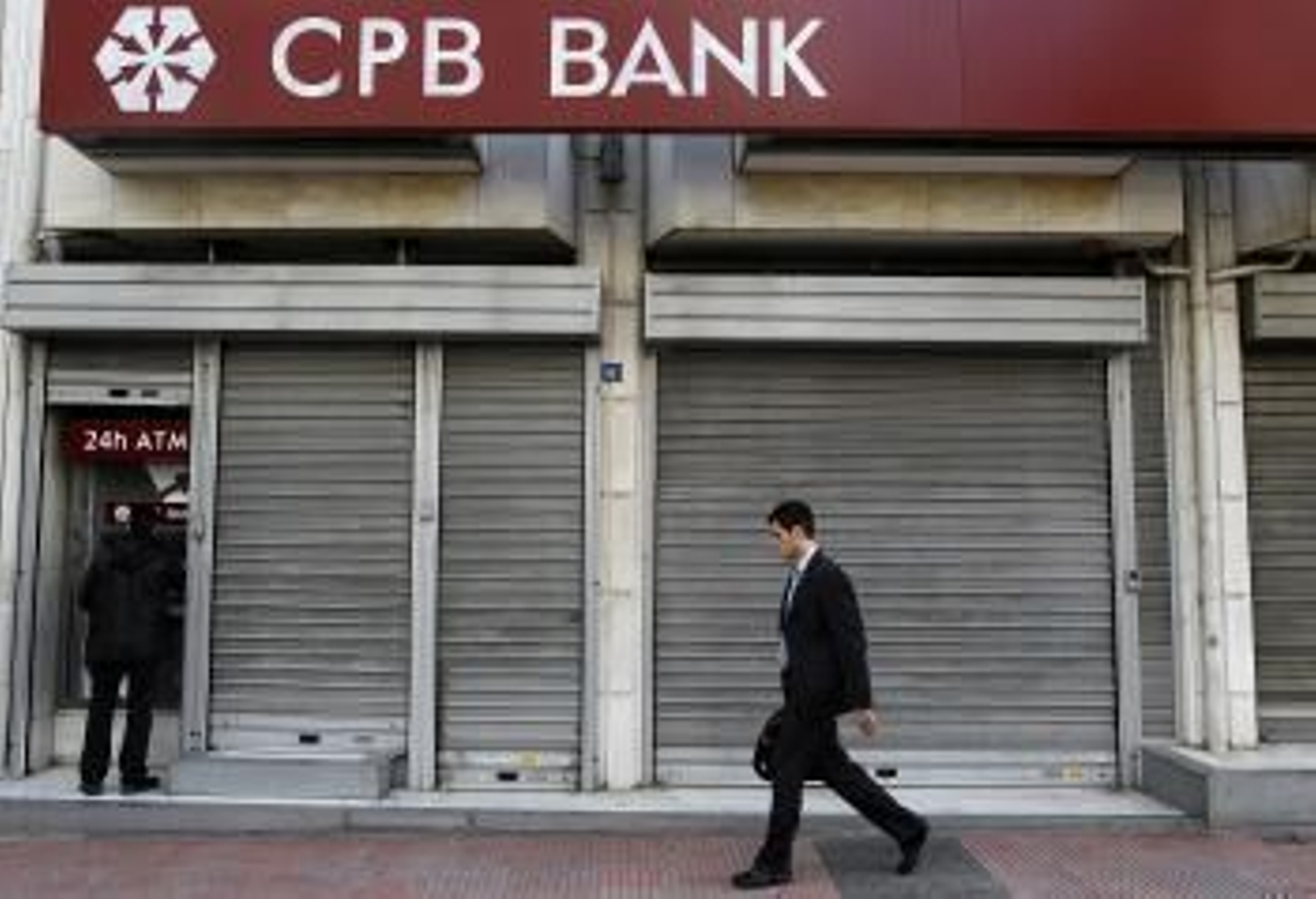Un hombre retira dinero de un cajero de una sucursal del Banco Popular Chipriota en Atenas (Grecia) (Foto: EFE)