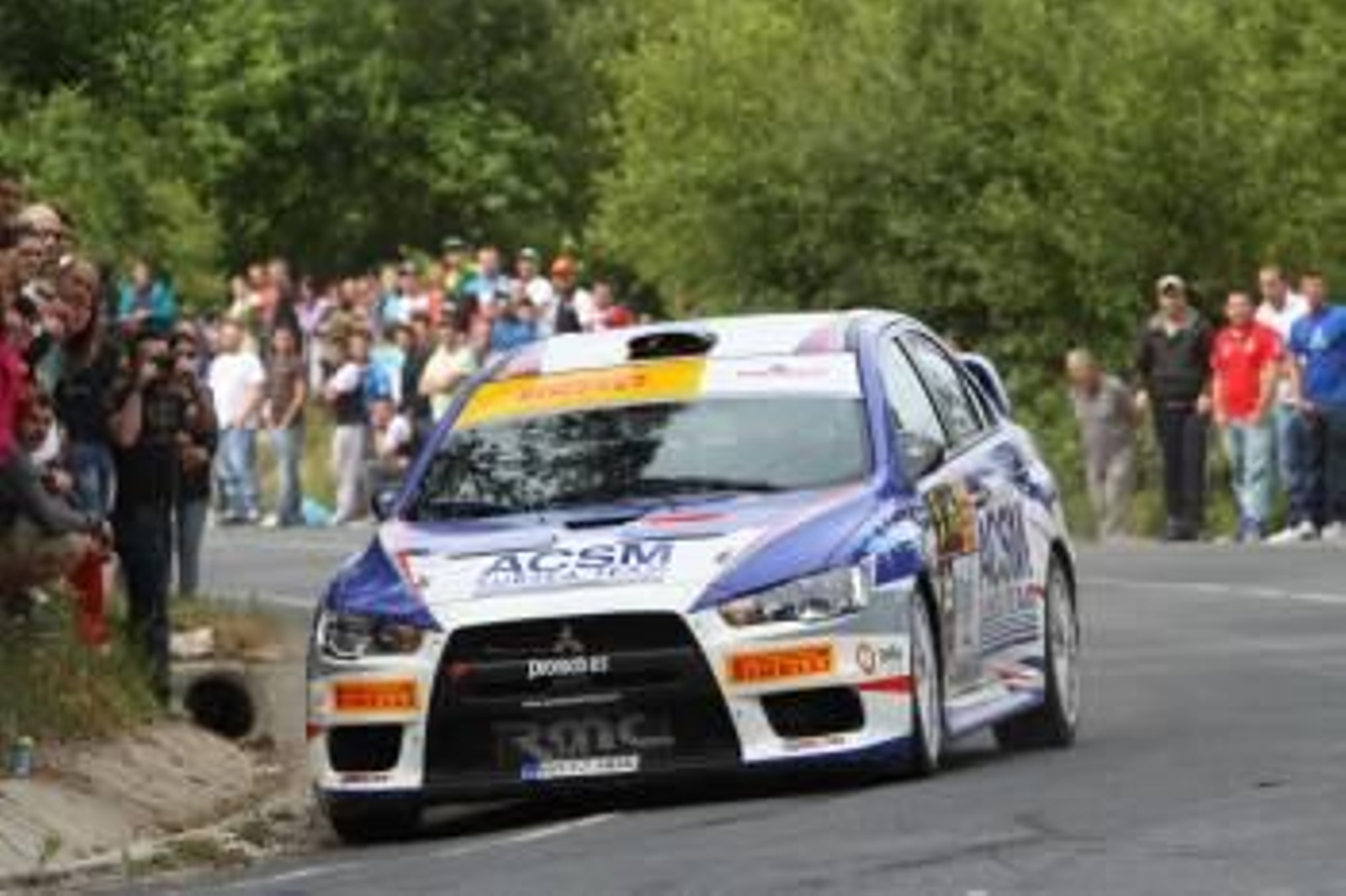 Uno de los participantes en la prueba pontevedresa traza una curva rodeado de aficionados.? (Foto: )