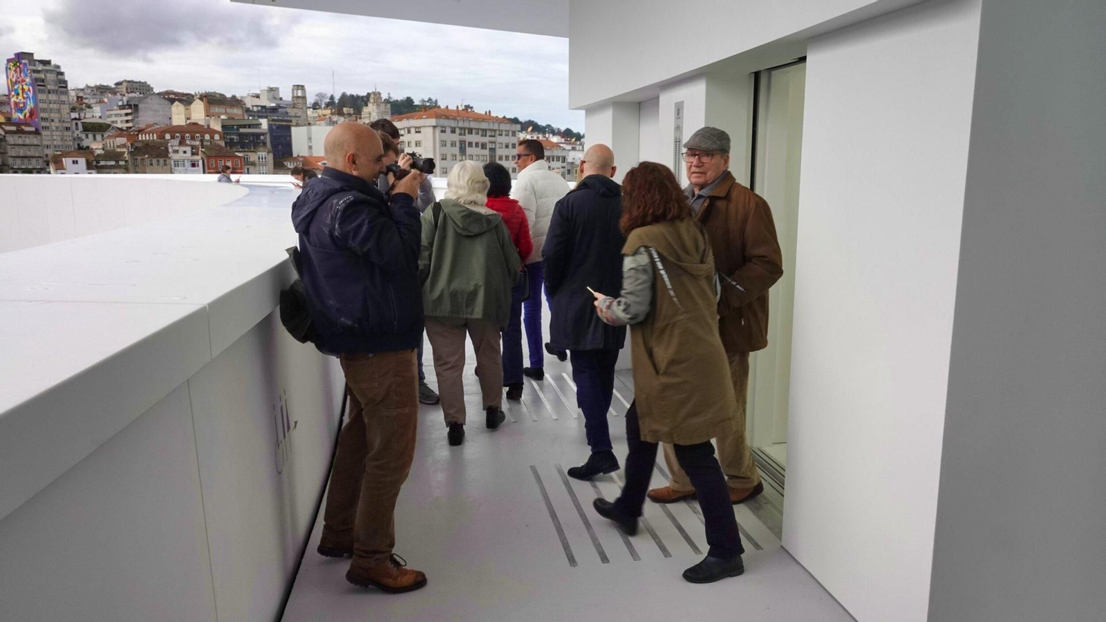 Varias personas salen del ascensor.