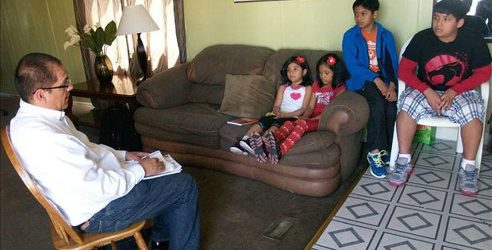 El escritor Arturo García durante una entrevista a pequeños cuyos padres fueron deportados.