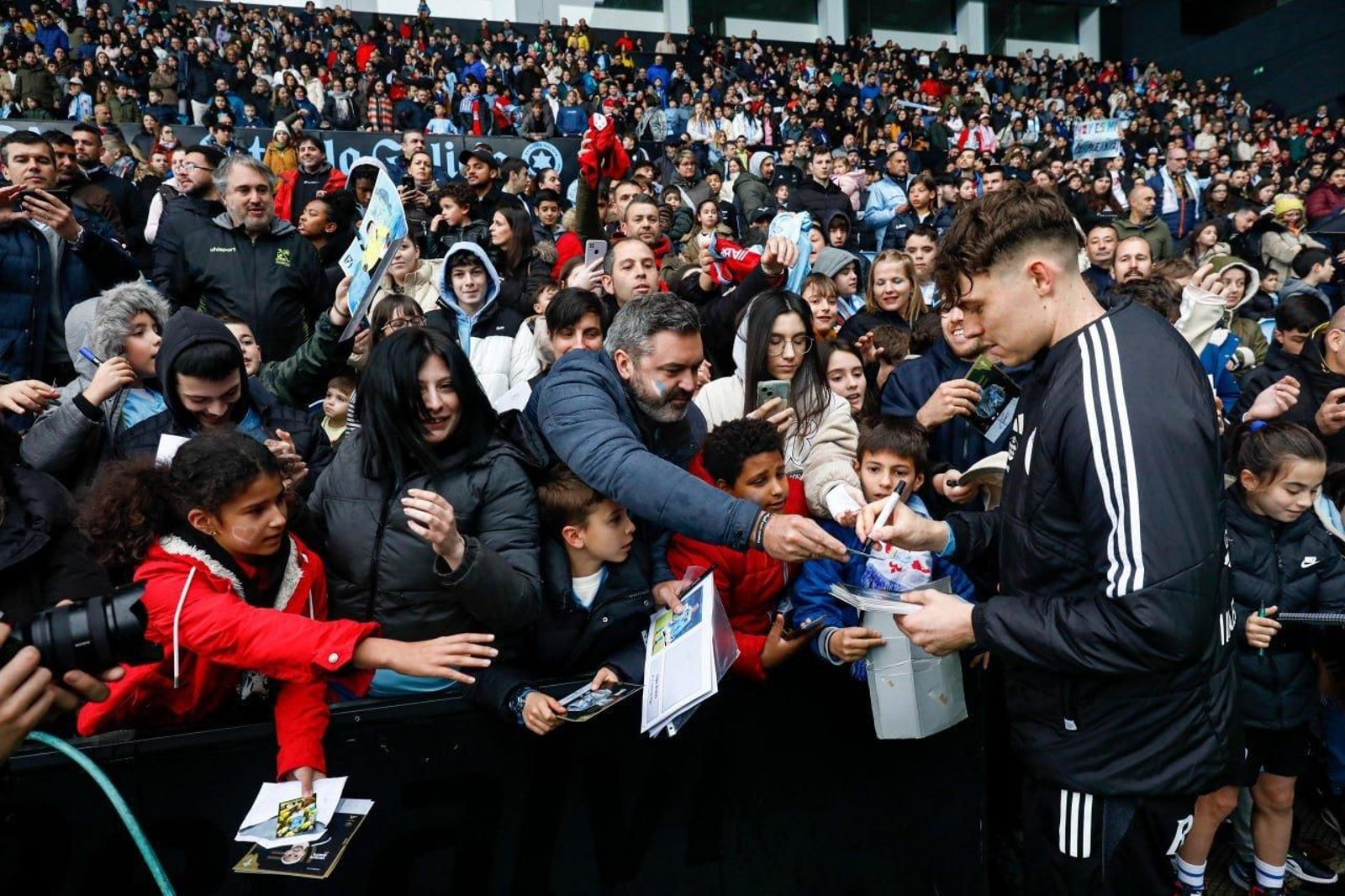 Larsen firma autógrafos.