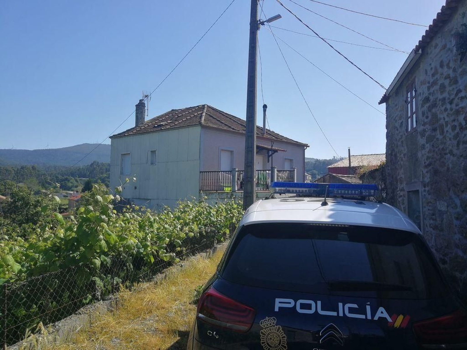 Un coche policial, en las inmediaciones de la vivienda en donde está atrincherado el arousano.