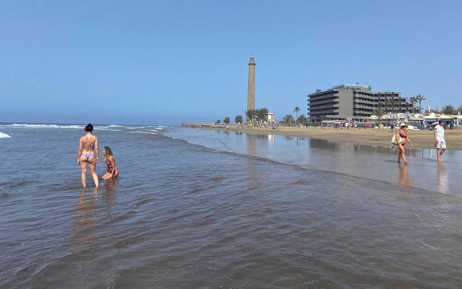 Vista inusual de la playa de Maspalomas con el faro al fondo, en una época en la que todo el litoral canario suele estar abarrotado de turistas. EFE/ José María Rodríguez