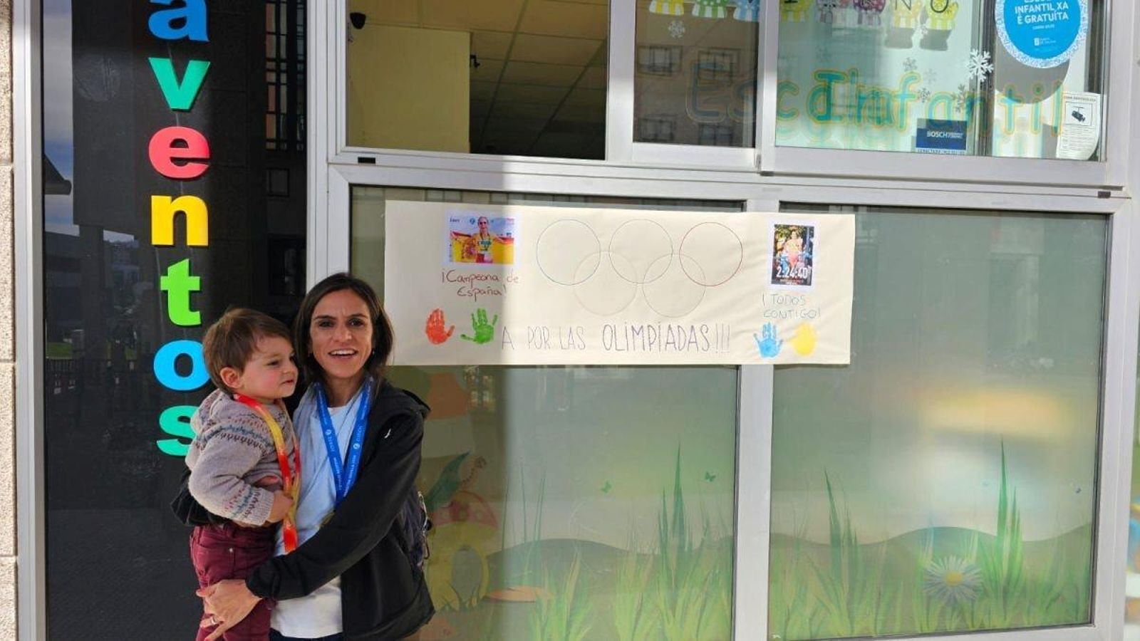 La atleta viguesa sostiene a su hijo con las medallas.