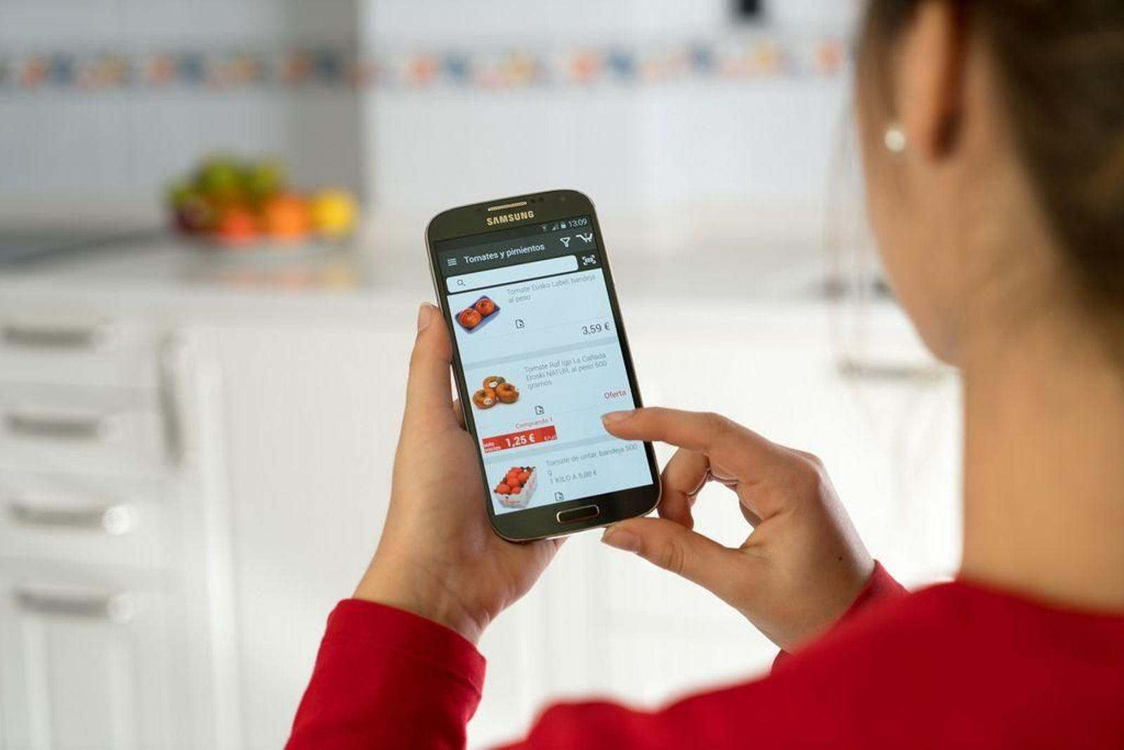 Una mujer realiza compras en un supermercado a través de su teléfono móvil.