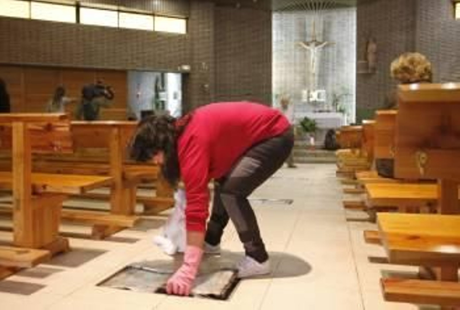 Una mujer realiza tareas de limpieza hoy en la iglesia de Santa María del Pinar, en el distrito de Ciudad Lineal, en Madrid, donde ayer un hombre mató a tiros a una mujer embarazada, hirió a otra mujer y se quito la vida.  (Foto: EFE)