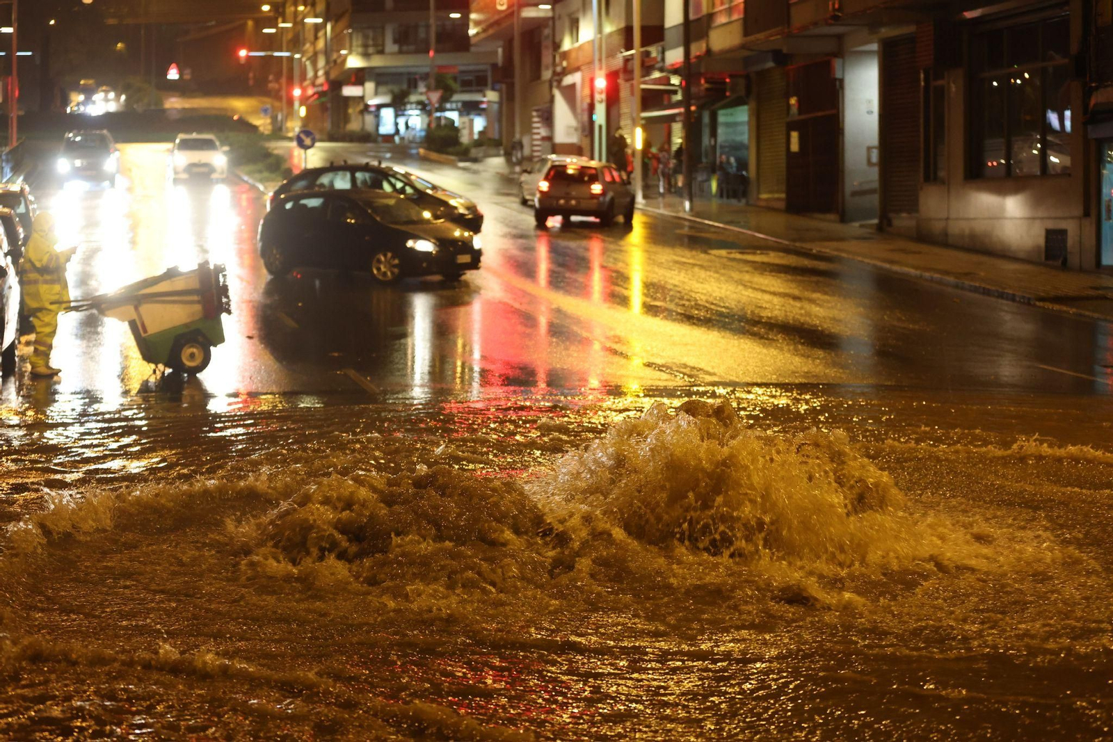 Los coches se paran ante una alcantarilla desbordada.