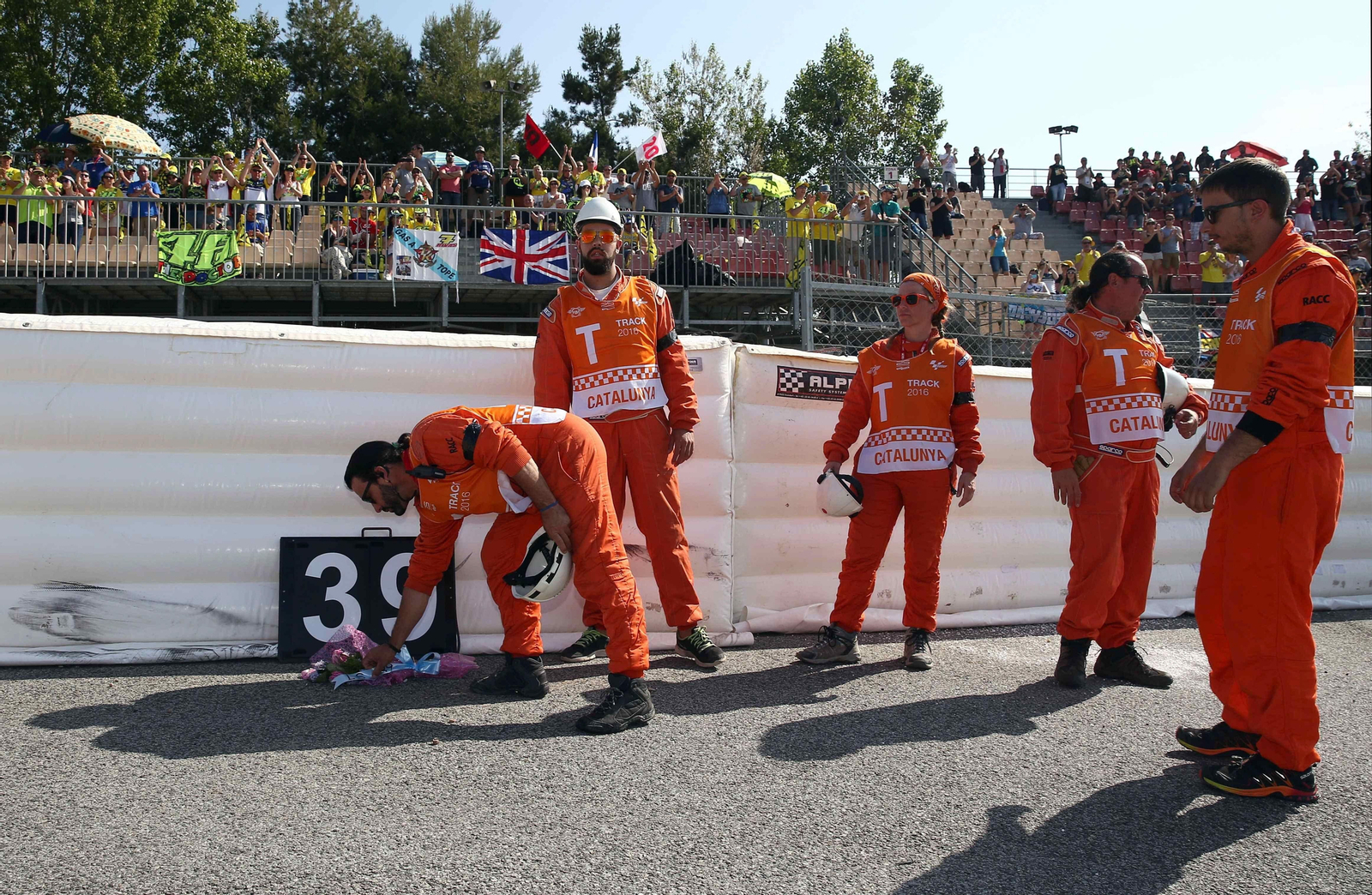 Un comisario deposita un ramo de flores en la curva del accidente.