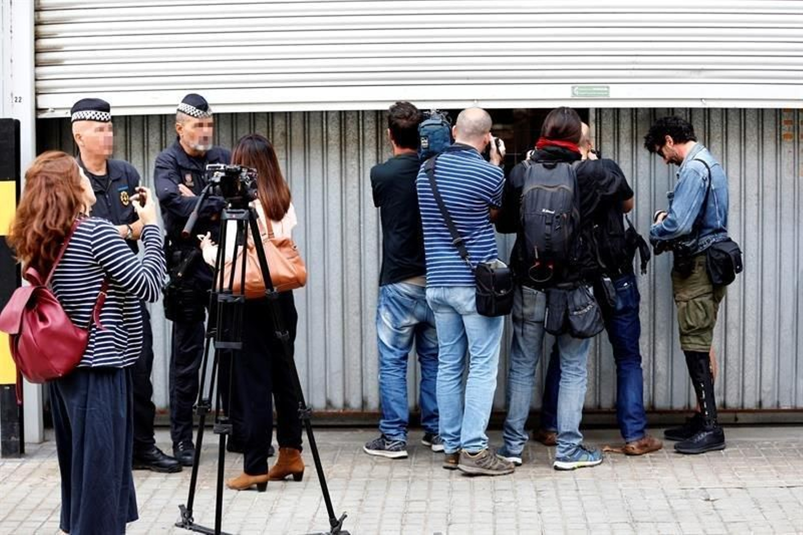 Fotógrafos y cámaras fotografían y graban el interior del almacén municipal donde se guardan las urnas pertenecientes al Estado