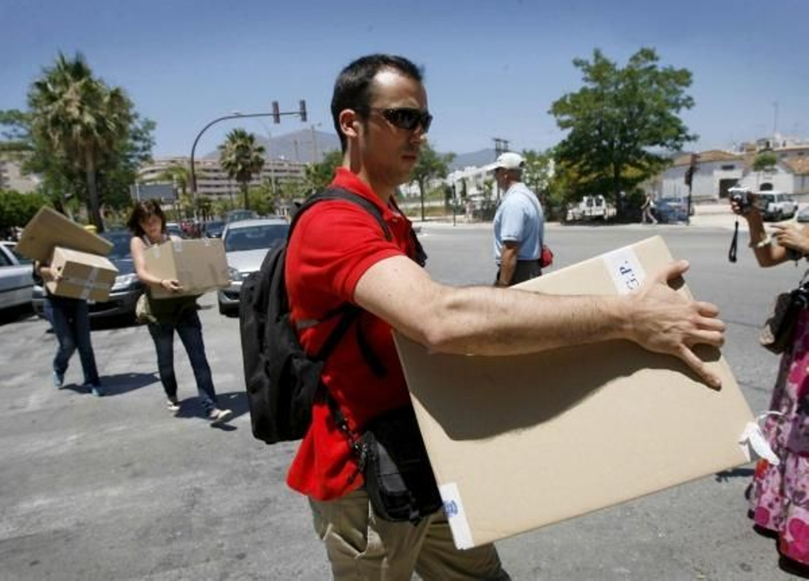 Un Policía traslada documentación del Juzgado de Estepona. (Foto: Jaro Muñoz)