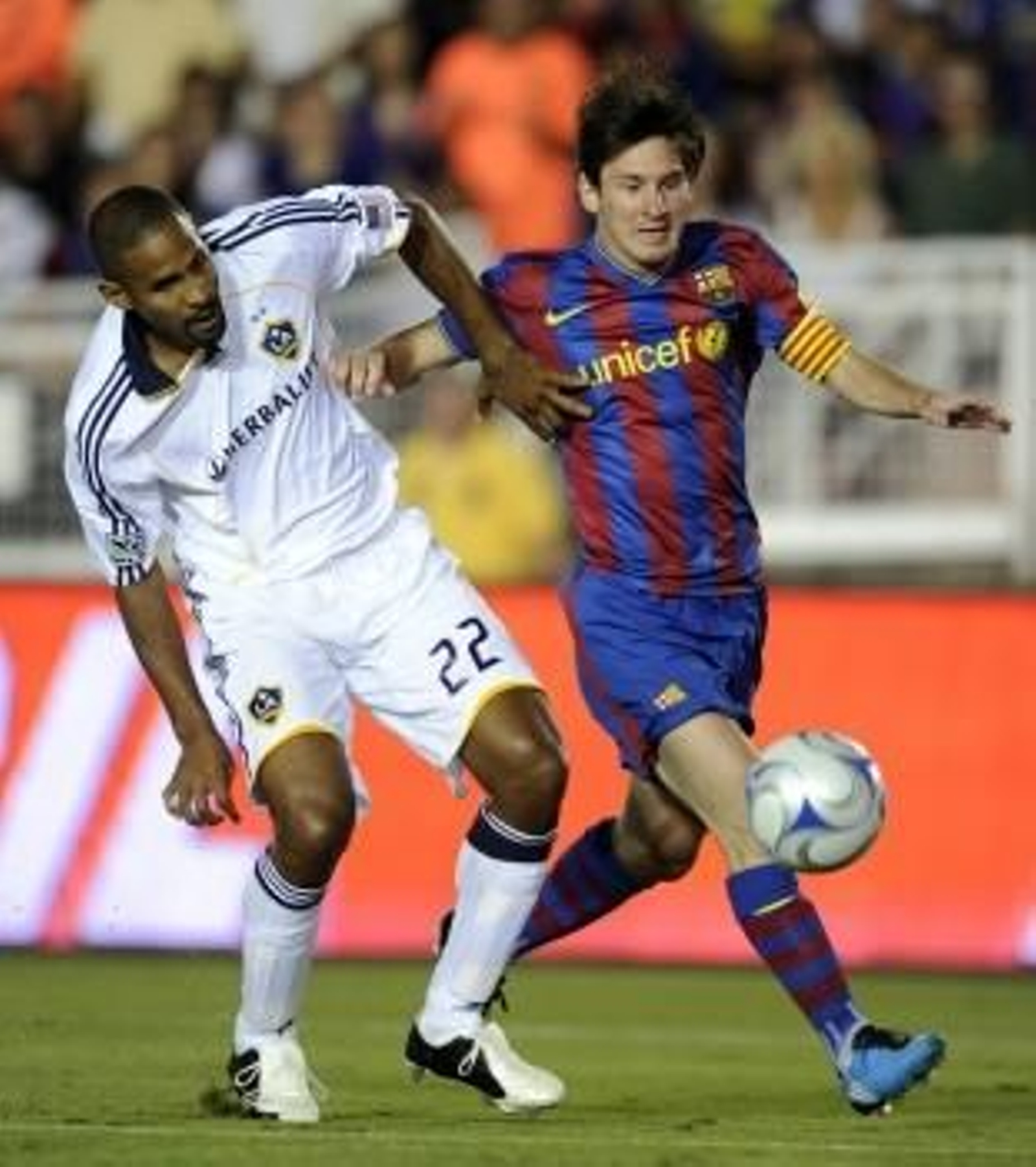 Messi disputa un balón con Tony Sanneh.