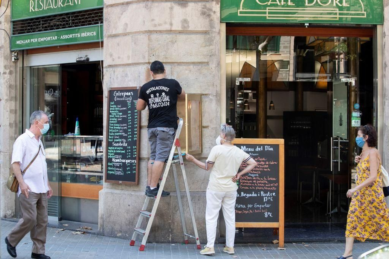 Unos trabajadores realizan tareas de mantenimiento en una cafetería.