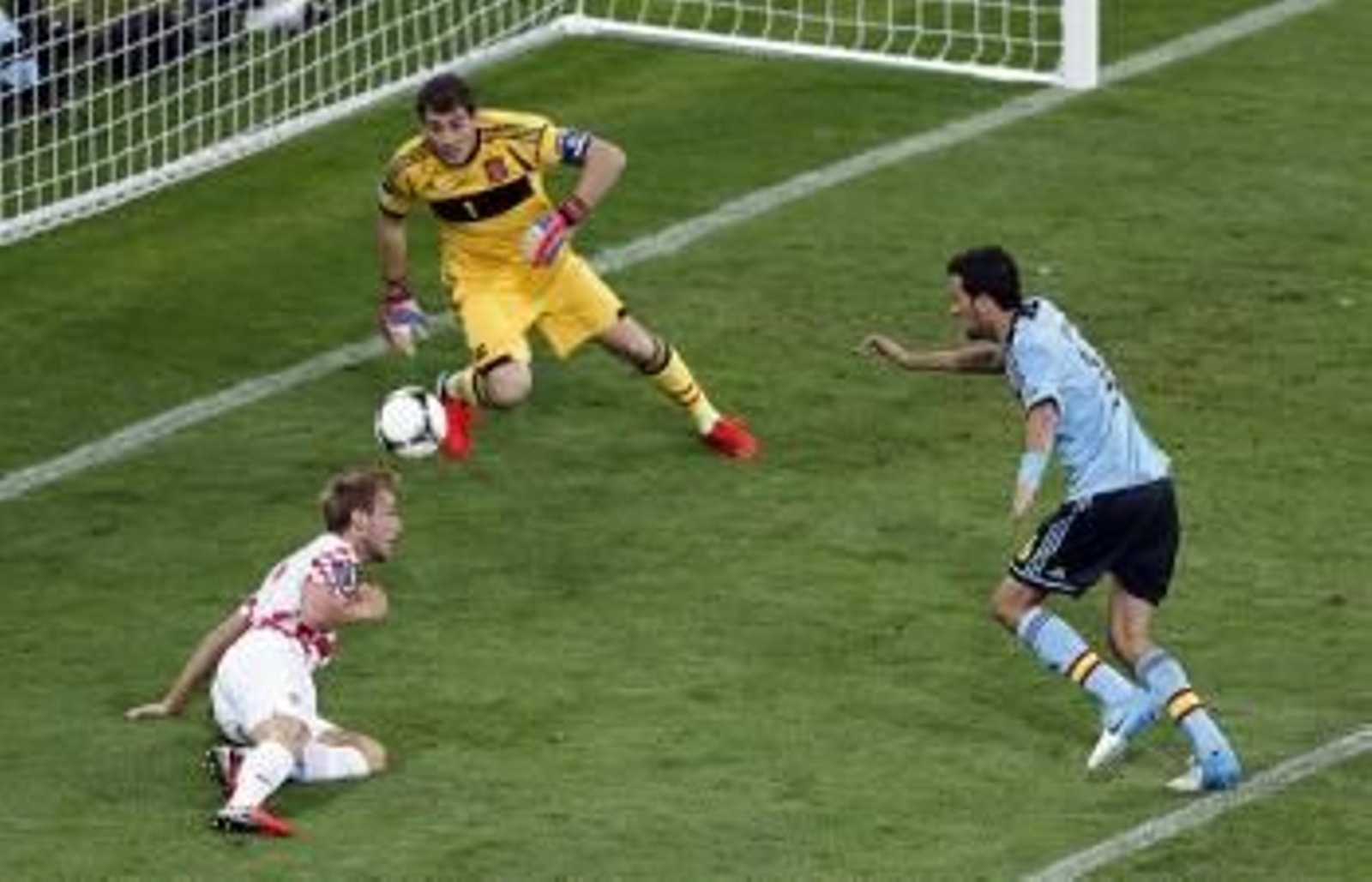 El jugador croata Ivan Rakitic (i) trata de convertir un gol ante los españoles Iker Casillas (c) y Sergio Busquets (d)