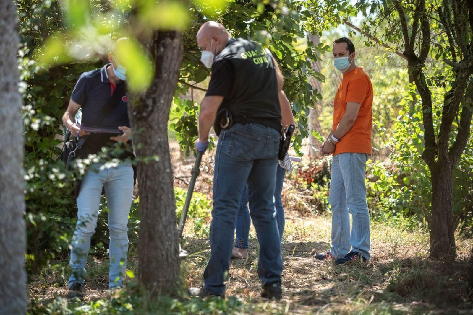 El acusado, a la derecha, observa a agentes de la Guardia Civil excavando en una finca.