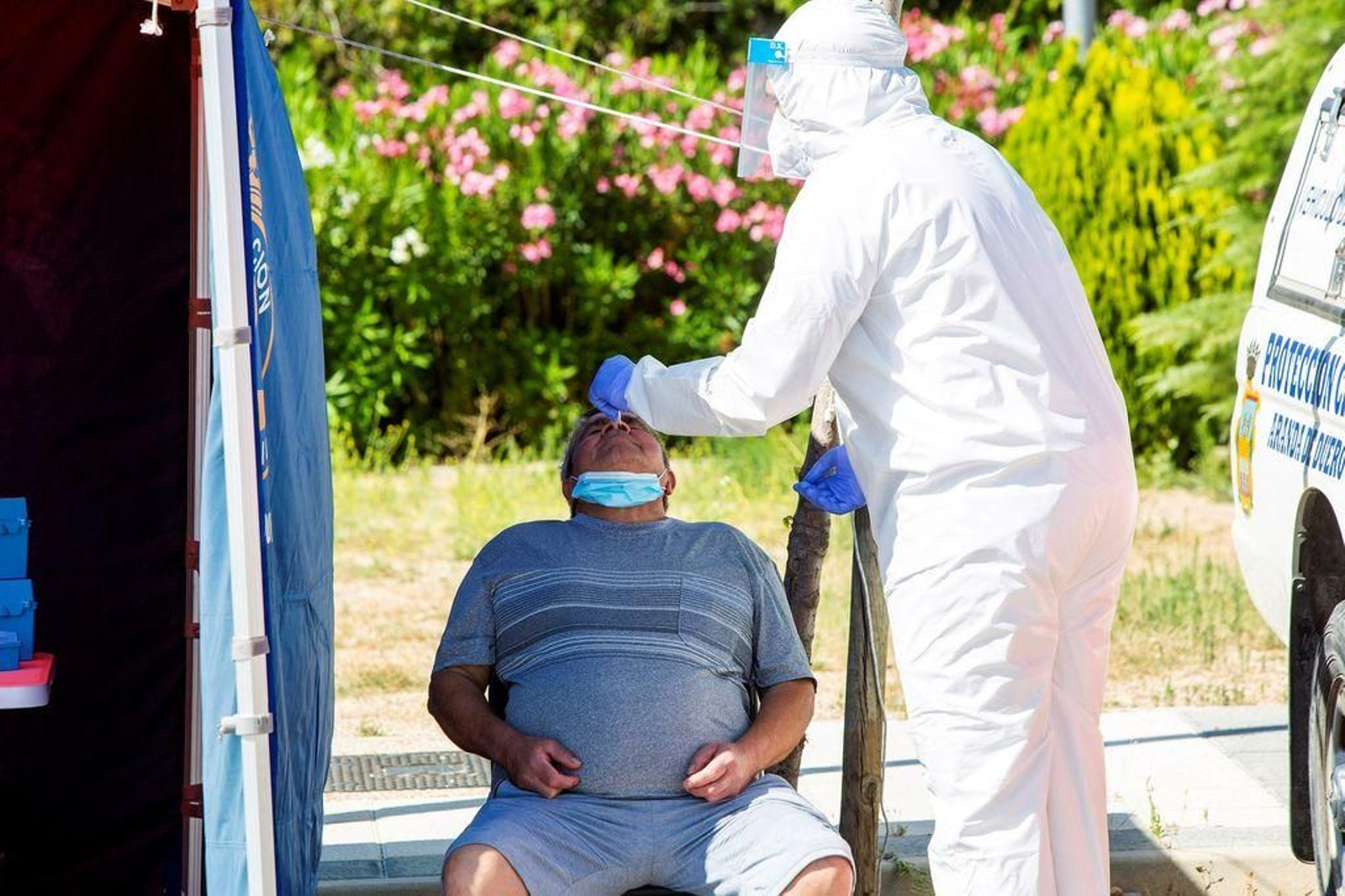 Un profesional sanitario efectúa una prueba PCR a un hombre.
