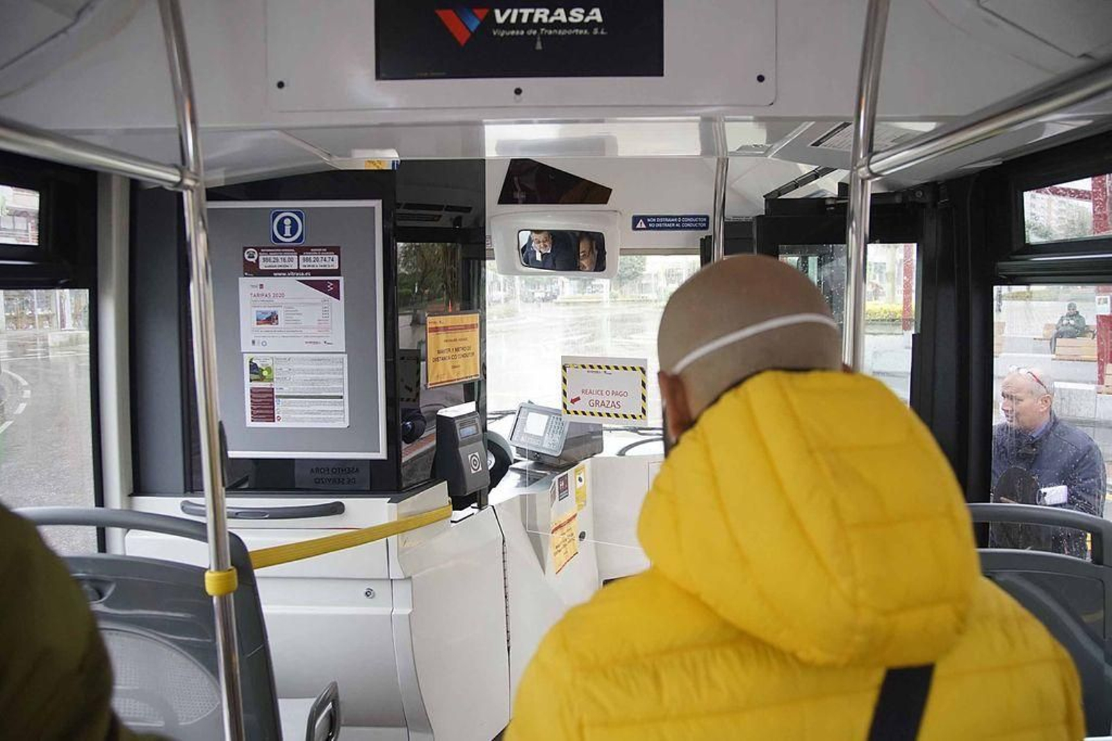 Un viajero de Vitrasa se dirige a la máquina de pago con tarjeta separada del conductor por una mampara.