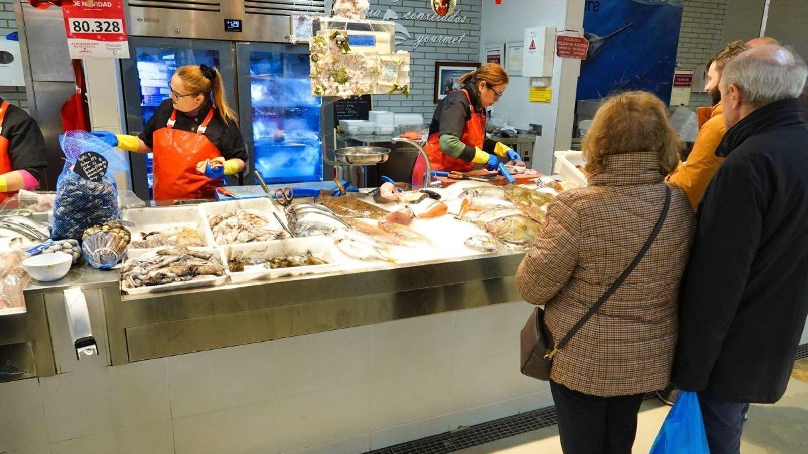 Trabajadoras de la pescadería Ana García, en O Progreso, atendiendo a clientes en el fin de la campaña navideña.
