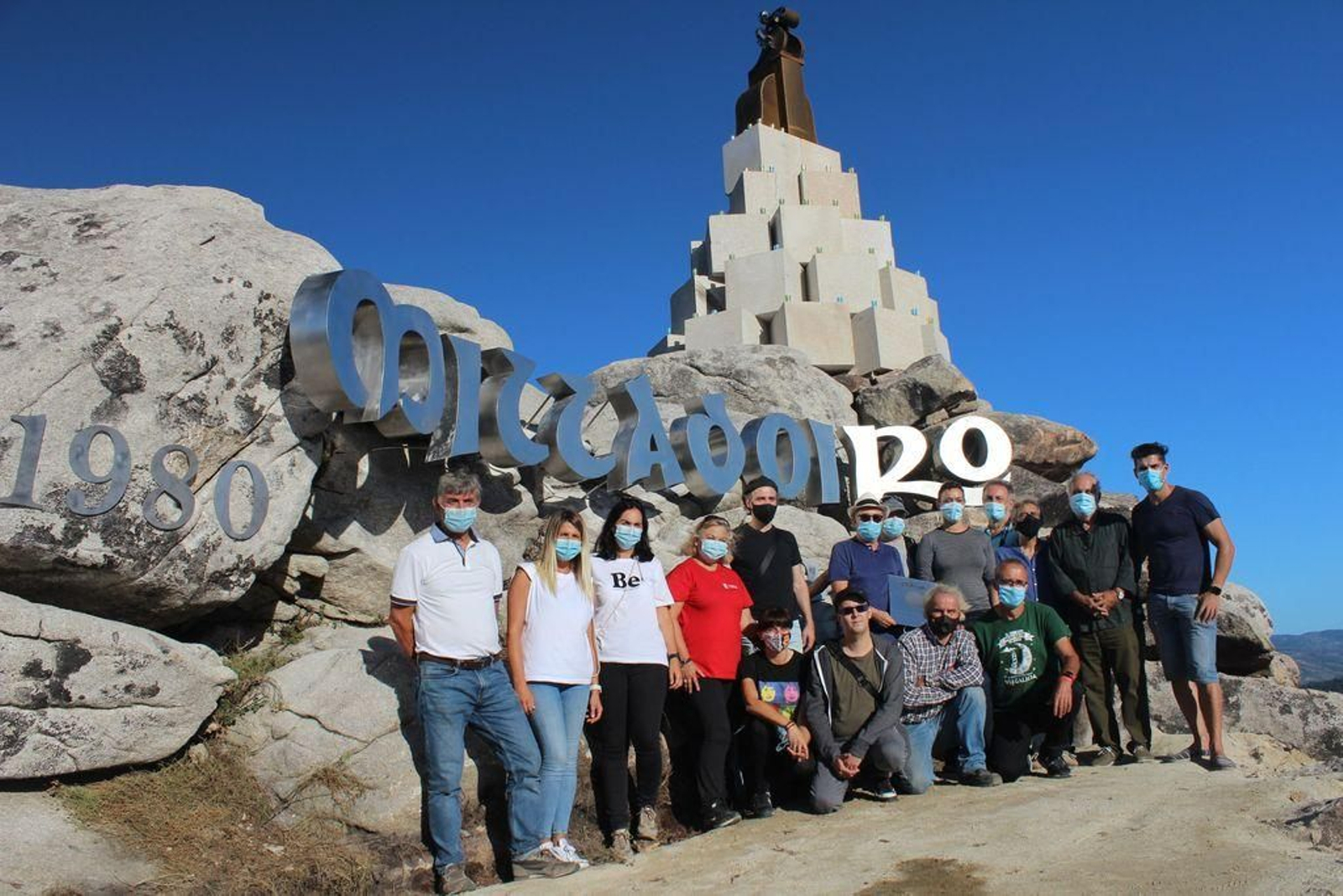 Los miembros de Milladoiro posan con el equipo de gobierno junto al monumento.