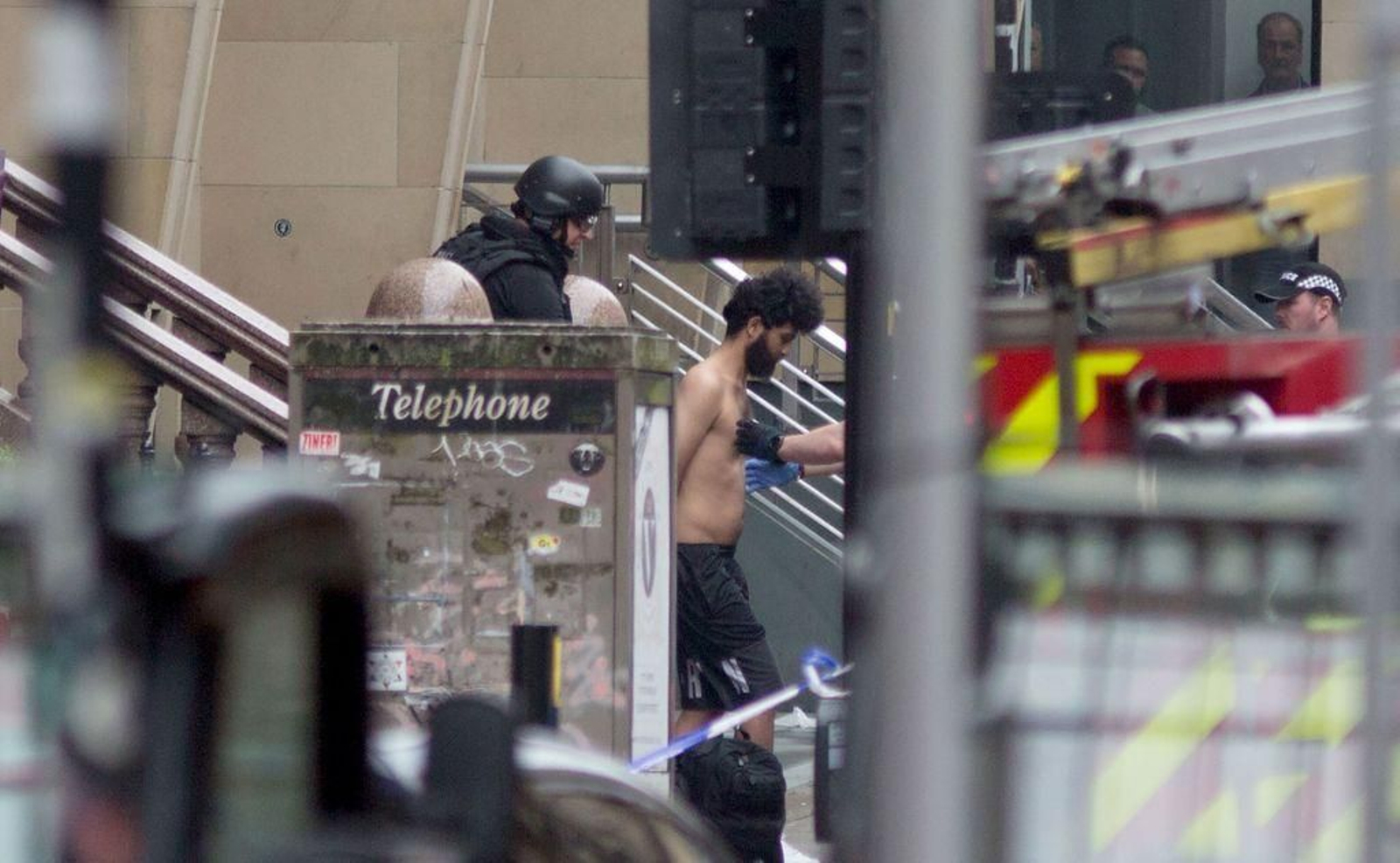 Un agente de policía sale a la calle con una de las personas que estaban en el lugar de los hechos.